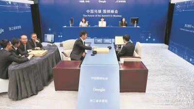 5位中国冠军级围棋高手时越、芈昱廷、唐韦星、陈耀烨和周睿羊，对抗AlphaGo。但5人合力仍不敌电脑，最终旗子投降。右为代AlphaGo落子的AlphaGo幕后研发人员之一黄士杰。