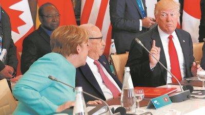 美国总统特朗普（右）上周六在意大利出席七国工业集团（G7）峰会，在席间与德国总理默克尔（左）交换意见时，露出不认同的表情。