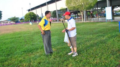 孙意志（左）劝告一名退休教师，不要再在公共草场打高 尔夫球。