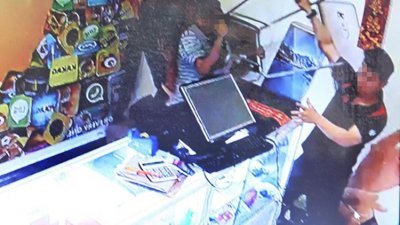 闭路电视电视画面显示，“火爆叔”（右）用椅子攻击店员。