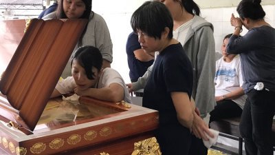 李子锋的母亲哀痛地伏在子锋的棺木上，也两次亲吻棺木的玻璃，向最亲爱的儿子告别。