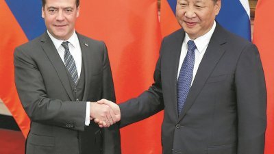 俄罗斯总理梅德韦杰夫（左）访华期间，与中国国家主席习近平会晤，商讨双边关系。