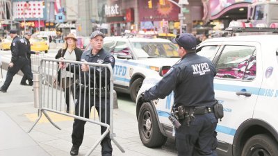 纽约发生货车撞人恐袭事件后，警察周三搬运栅栏，准备在时报广场增设执勤点加强安保。