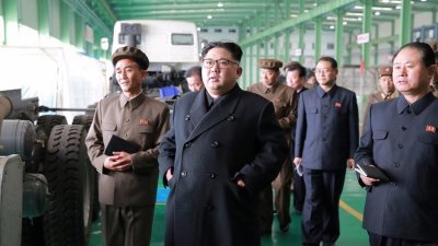 朝鲜官方媒体朝中社，周六发放该国最高领导人金正恩（中），视察工厂的照片。