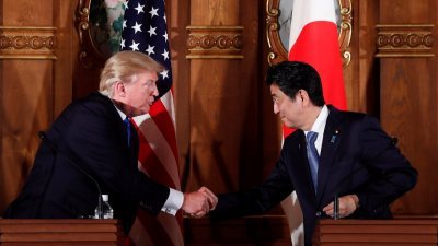 特朗普（左）周一和日本首相安倍晋三举行会谈后，在赤阪迎宾馆召开联合记者会。两人在记者会上握手致意。