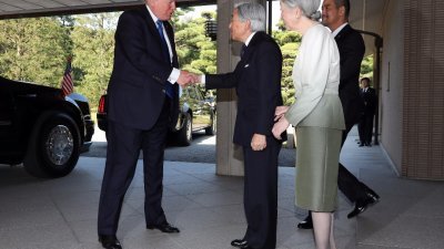 特朗普周一前往东京皇宫，日皇明仁与皇后美智子在门外迎接。