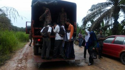 7名住在甘榜的加亨国中生，因前往学校的主要通道淹水而无法通行，必须由消拯员安排罗里，载送他们到校。