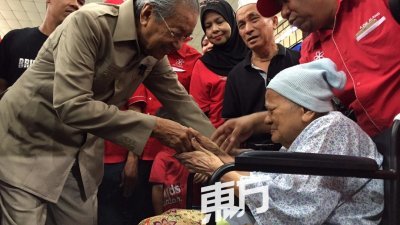 敦马哈迪（左）周三探访威北双溪赖灾民疏散中心，慰问已失明的80多岁老妇仄阿玛，关心其情况。（摄影：吴维康）
