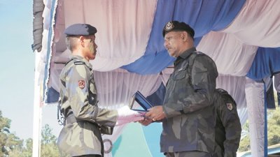 荣获体育最佳表现奖的普通警员许佳耀（左）从纳仁沙嘉兰手中接过奖品。