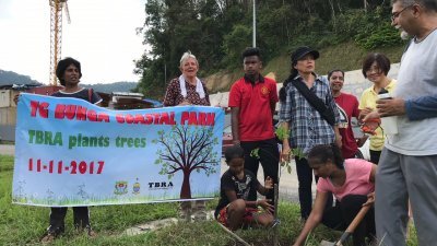 丹绒武雅居民协会秘书安娜（左2）与艾娜斯（右2蹲者）周六早上拉大队前往丹绒武雅工地土崩现场附近种植30棵树苗，以纪念11名因土崩身亡的死者。