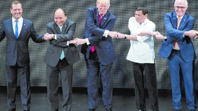 特朗普（中）周一在菲律宾首都马尼拉出席东盟峰会开幕仪式时，与各国领袖手拉手拍照，右2为东道主菲律宾总统杜特蒂。
