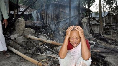 眼见房子被烧毁，老妇无奈抱头痛哭。