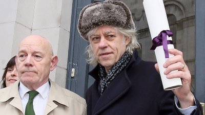 爱尔兰歌手格尔多夫（右）在周一向都柏林市政府归还都柏林自由奖的奖状。-法新社-