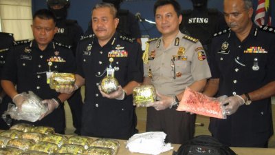 武吉安曼肃毒组副总监拿督卡马鲁（左起）、罗斯里、印尼驻马大使馆警察查迪尔及槟州肃毒组主任麦都展示警方起获的毒品。（摄影：黄俊南）