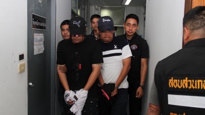 两名涉嫌电话诈骗的大马籍男子，周六在泰国曼谷遭警方扣押到警局盘查。