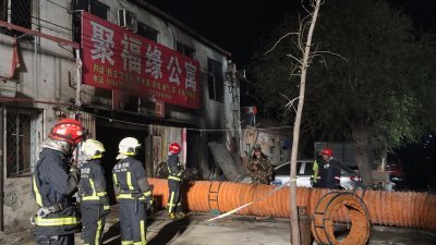 北京大兴西红门镇新建村一栋公寓遭遇火灾后，现场明显可见火烧痕迹，消防员在现场展开清理和搜寻工作。