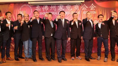 颜清水（左4起）、陈万利与理事们，在柔州家电商公会的15周年联欢晚宴上，一同进行敬酒仪式。（摄影：刘维杰）