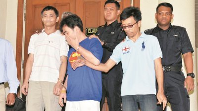 3名被告周一被警方押到法庭面控，期间首脑刘志忠（左2）用手遮脸，避免样貌曝光。  摄影：曾钲勤