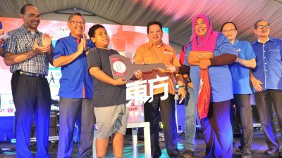 东姑安南（右2）出席联邦直辖区“我的国家，一个马来西亚”活动上，颁发奖品给幸运儿，左为依布拉欣。（摄影：陈为康）