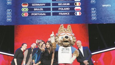 将于周五晚参与2018俄罗斯世界杯抽签仪式的工作人员，把握机会在现场与吉祥物——西伯利亚狼“扎比瓦卡”合照。