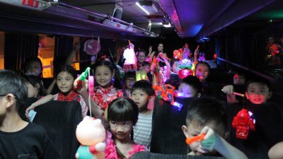 小孩子们提著他们喜爱的电子灯笼，在巴士上庆祝难忘的中秋节。
