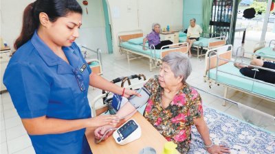 护理人员定期为老人量血压等，跟进老人的健康状况。（摄影：刘维杰）