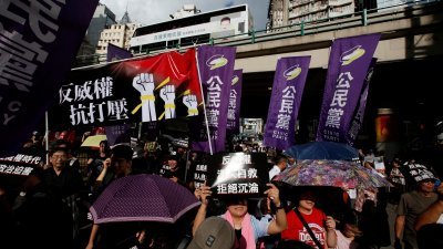 香港泛民主派活动人士在周日中国国庆日当天，拿著布条和海报上街示威，反对中国中央政府打压。