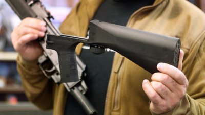 犹他州盐湖城一家枪械店老板，展示“撞火枪托”。对拥枪立场态度向来强硬的美国全国步枪协会，罕见要求有关当局立即检讨“撞火枪托”是否合法。