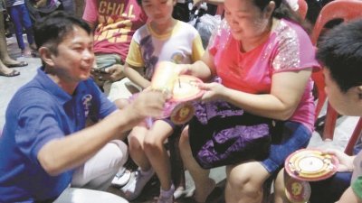 道文小学举办中秋节园游会，张秀福（左）为家长和小学生点燃蜡烛，一起庆祝中秋节。