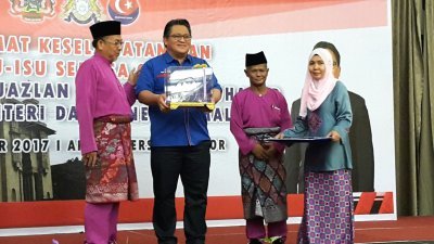 诺嘉兹兰（左2）周日出席第43届马来西亚半岛村长协会代表大会，针对国家安全课题发表演讲，接获大会赠送的纪念品。左为阿末法勿。