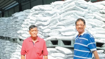 叶光华（左起）与刘国才巡视巴西班让农民组织局的货仓时，发现尚有大批肥料准备运送给农民。