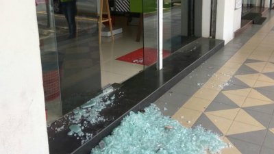 理发店遭爆窃，玻璃门被砸碎，地板全是玻璃碎片。