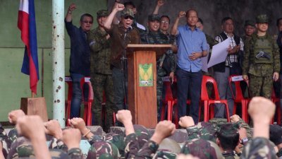 菲律宾总统杜特蒂（中）周二在祝捷仪式上，带领在场军人手握拳头高呼解放马拉维市。-法新社-