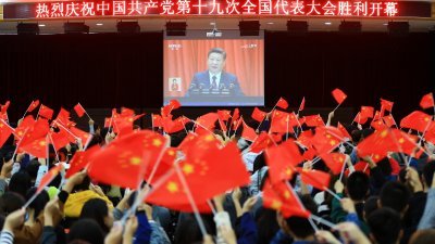 周三在安徽省淮北市一所高校内，学生们在观看习近平演讲时不停挥舞手中的中国国旗。-法新社-