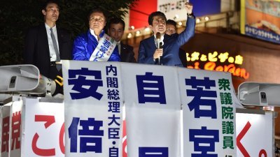 日本首相、自民党总裁安倍晋三（右），周五晚乘搭选举宣传车，在首都东京街头拜票，为周日的大选冲刺。
