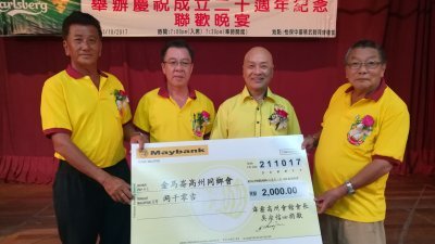 吴宗信（左起）在杨佐明及胡朝栋的见证下，移交2000令吉捐款予金马仑高州同乡会，由张荣华代表接领。