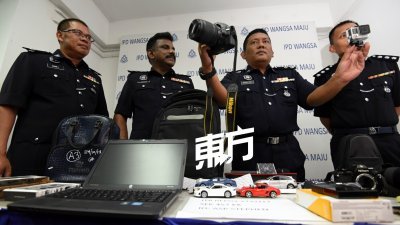 莫哈末洛（右2）在建功警官的陪同下，向媒体展示由警方所起获的部分失窃物品。 （摄影：黄良儒）