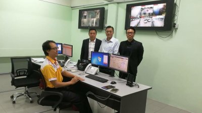 杨俊彬（站者左起）、杨金同及尤泇为，巡视24小时操作的呼叫中心。
