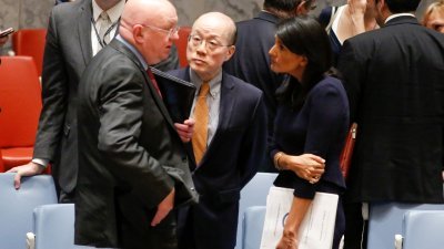 联合国安理会周一举行紧急会议，美国常驻联合国代表黑利（右）与中国代表刘结一（中）以及俄罗斯代表涅边贾在会议后交谈。-法新社-