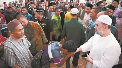 国家元首苏丹莫哈末五世（右）周五前往吉隆坡占美清真寺进行午间祈祷后，接受民众的问候和祝贺，尽显亲民作风。