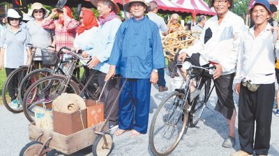 民众换上古装旧服，手拿开垦工具，浩浩荡荡地参与“双九节”大游行。