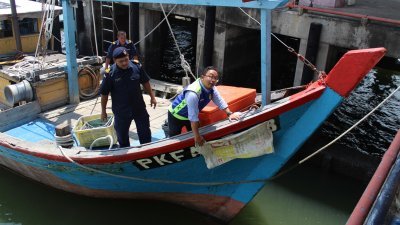 卡西米（右起）及曼苏向媒体展示渔船为了违规作业，用面粉袋遮挡船头的船牌。