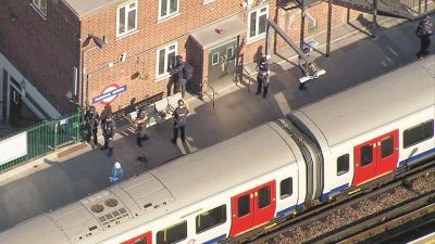 英国首都伦敦的地铁周五发生炸弹事件，政府已将事件定性为恐袭，并提升恐袭警示，伦敦市内保安升级。图为周五发生爆炸的地铁，站内有数名警员驻守。警方相信袭击者在土制炸燀引爆前的一两站下车。