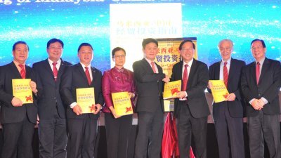 李志亮（右4））推介《马来西亚─中国经贸投资指南》，并获陈友信（右3）赠送这本指南。左起为林顺平、黄振兴、卢国祥、石资明、陈凯希及郭隆生。 （摄影：陈为康）