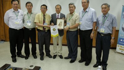 陈治光（左5）代表留台联总赠送纪念品予台湾侨务委员会委员长吴新兴（中）。左起为柯文焕、余安、洪进兴、郭应茂及刘志强。