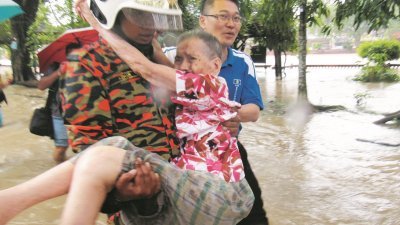 一名消拯员到亚罗士打丹绒查理救出受困的91岁老妇，马华亚罗士打区会副主席陈勇桦（右）到现场协助。