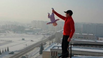 阿芬拿斯夫曾站在大厦天台的边缘，仅以单手捉着女婴的左脚。（照片取自网络）