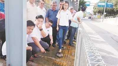 王欣怡（右起）在张志辉、朱俊文及马华党员陪同下，巡视长满青苔的有盖人行道，并向记者示范路人是如何踩著小砖块越过污水。