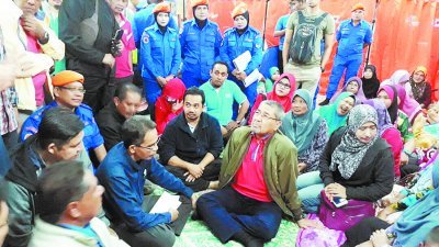 吉打大臣阿末峇沙（左3）和相关单位官员席地而坐，聆听灾民的心声。