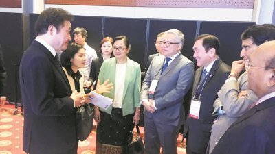 韩国总理李洛渊（左）与黄家泉（右3）等各国代表交流。